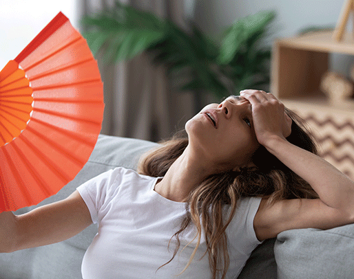 a woman with a fan who is overheated because her air conditioner needs to be repaired